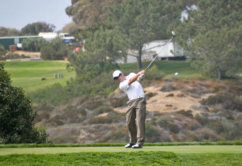 a man swinging a golf club at a green