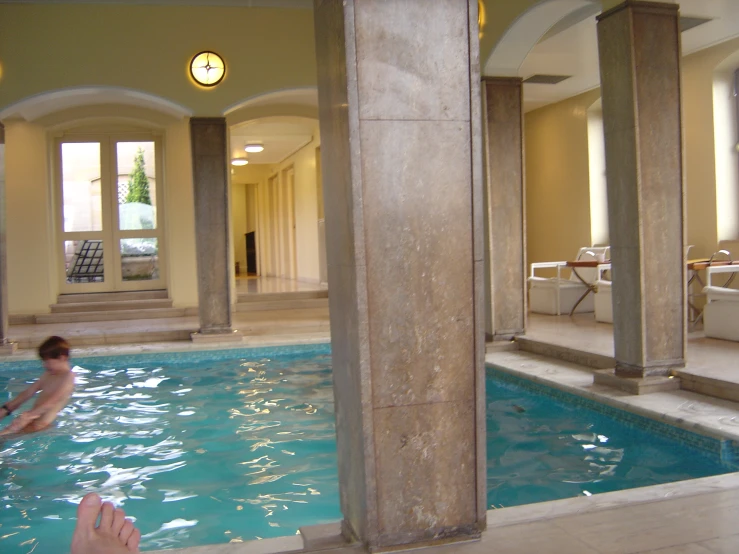 a man in a pool surrounded by columns