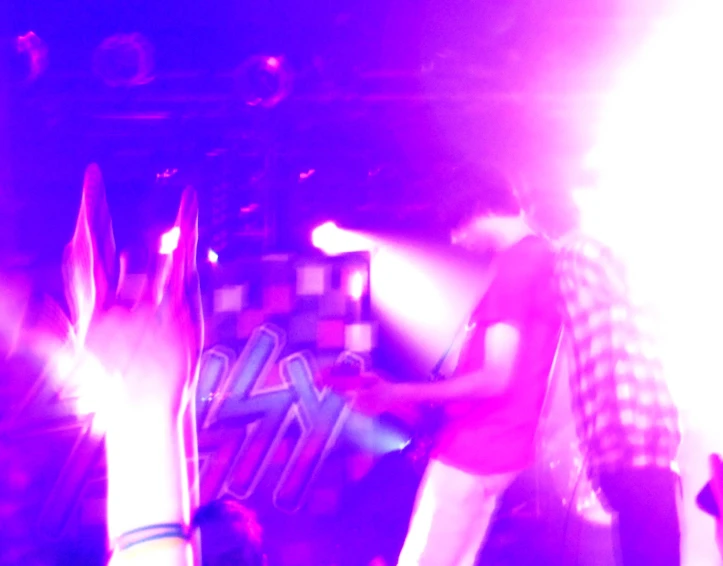 a man standing on stage with a skateboard next to his feet