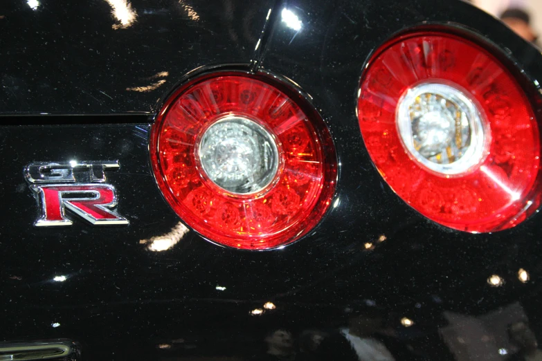 the rear end of a sports car with round red lights