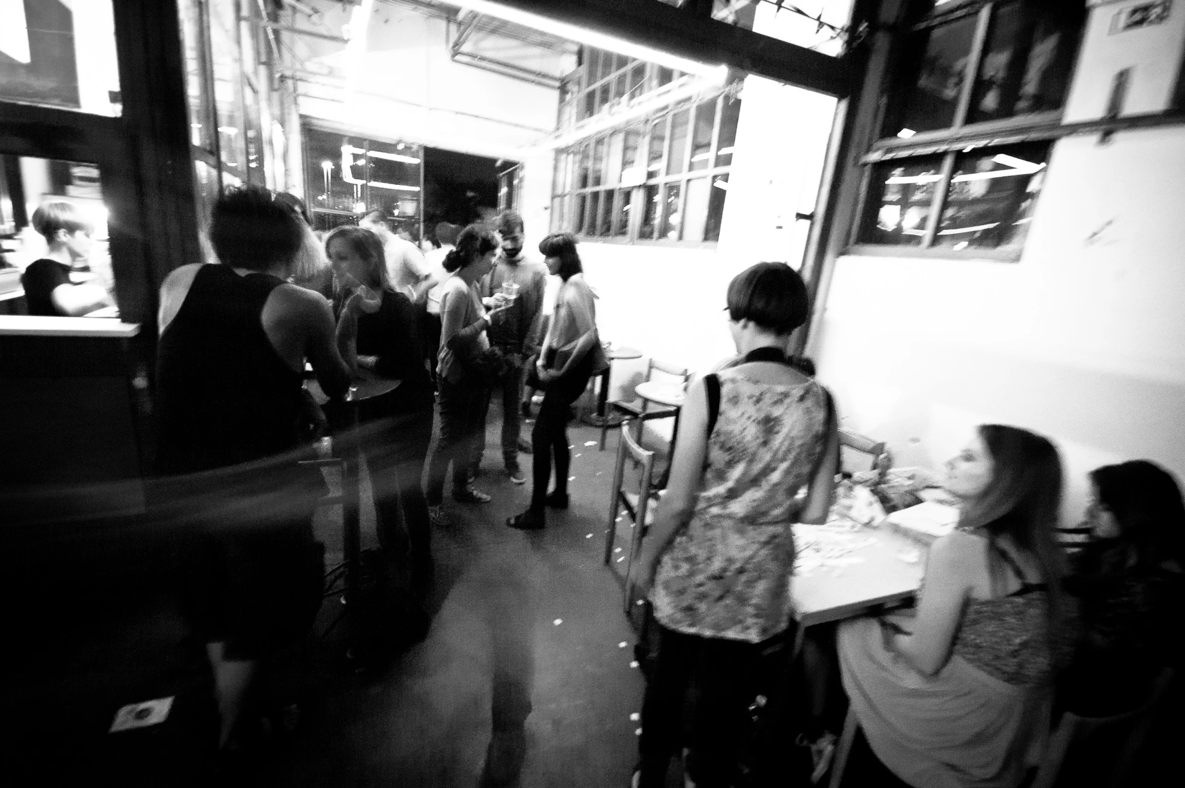 black and white pograph of people standing around in a narrow hallway