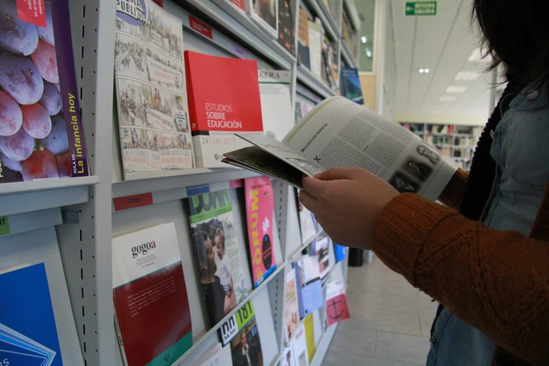 a person reading in the aisle of a store