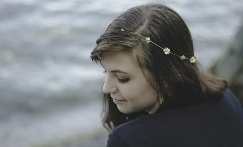 girl with flowers in her hair staring away from the camera