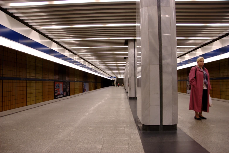 an older woman is standing in a large empty area