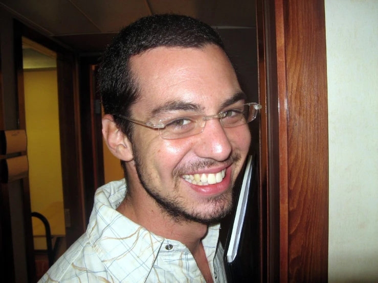 smiling man with glasses standing in hallway