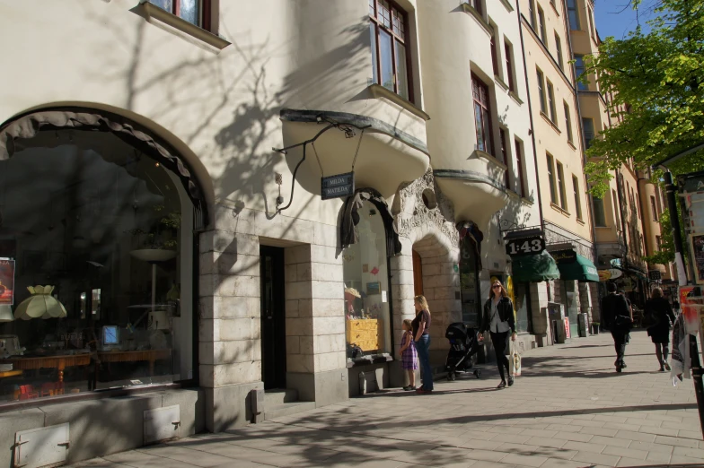 people are walking down a cobblestone street in an urban setting