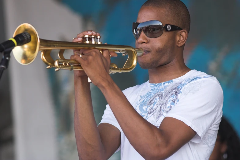 a man in sunglasses plays a ss trumpet