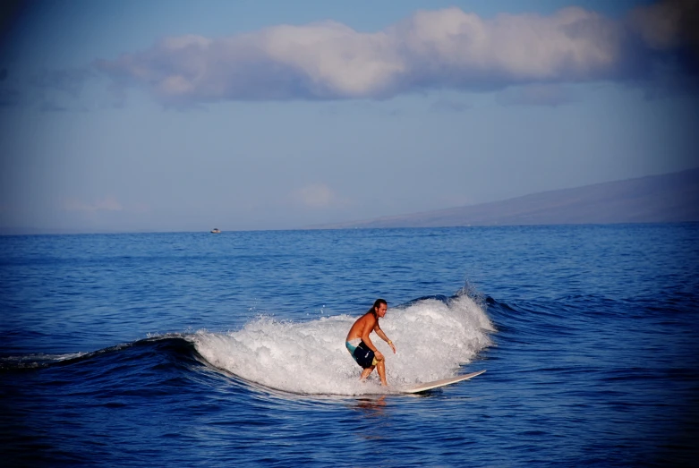 a young man riding on top of a wave in the ocean