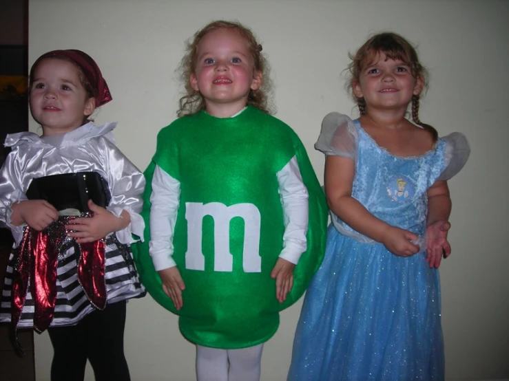 three s in costumes wearing luigi's super mario costume