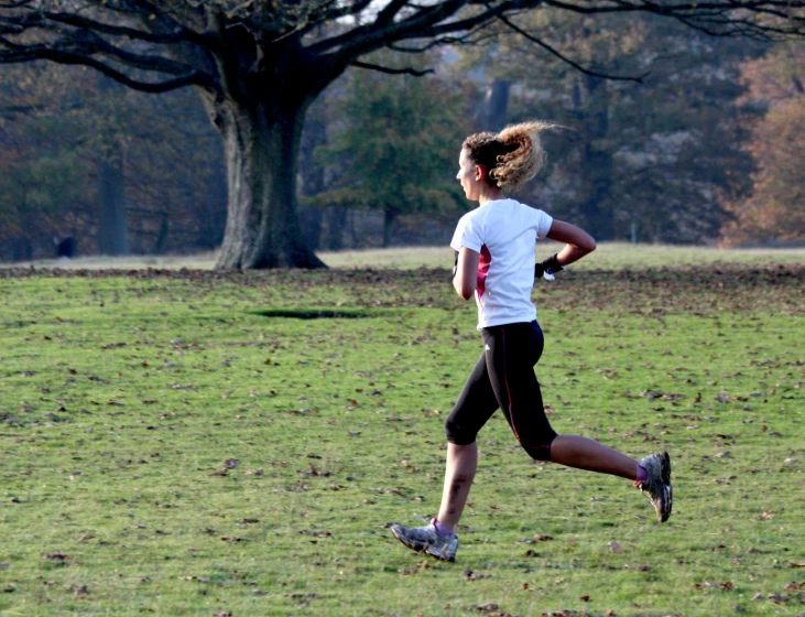 a woman runs in a field on a sunny day