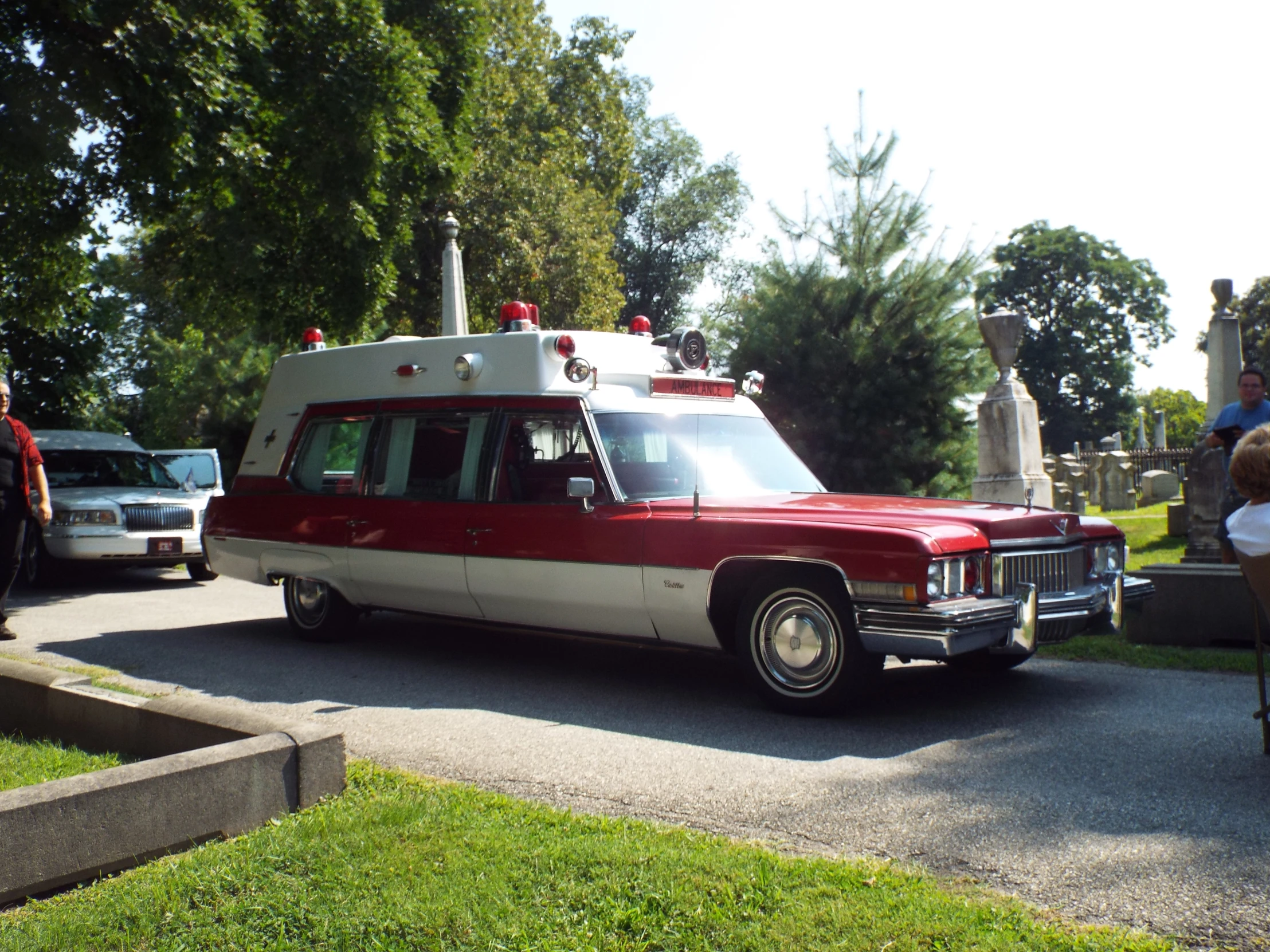 a red and white ambulance drives down the street