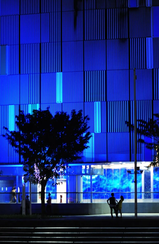 people are sitting on the stairs near a large building