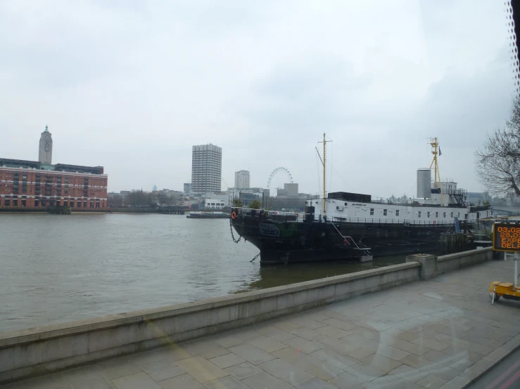 the ship is parked by the curb in front of a large body of water