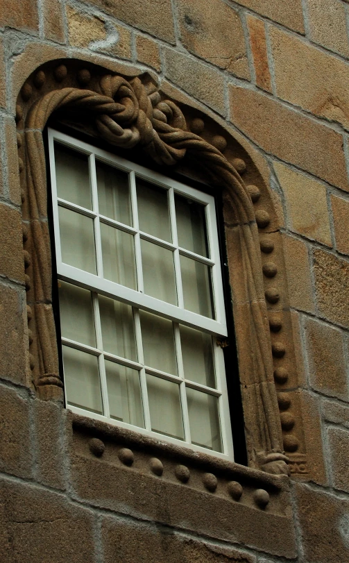 a white window in the brick wall of a building