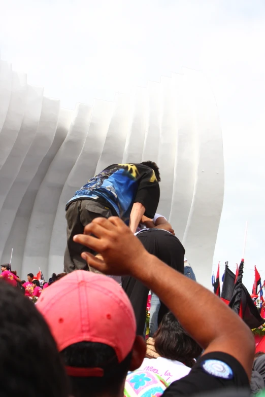 a large crowd is standing near a sculpture