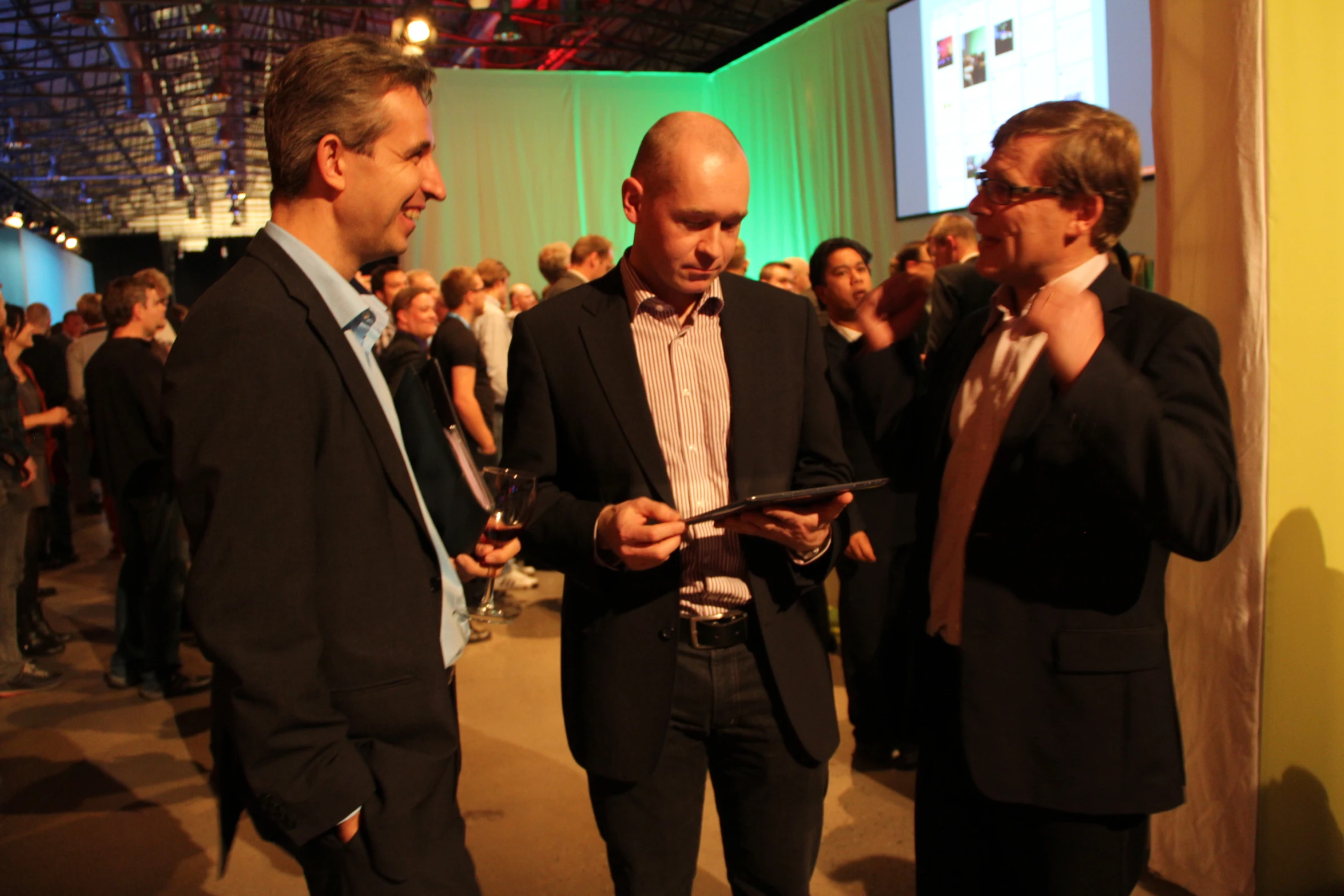 several people standing in line at an event with cell phones