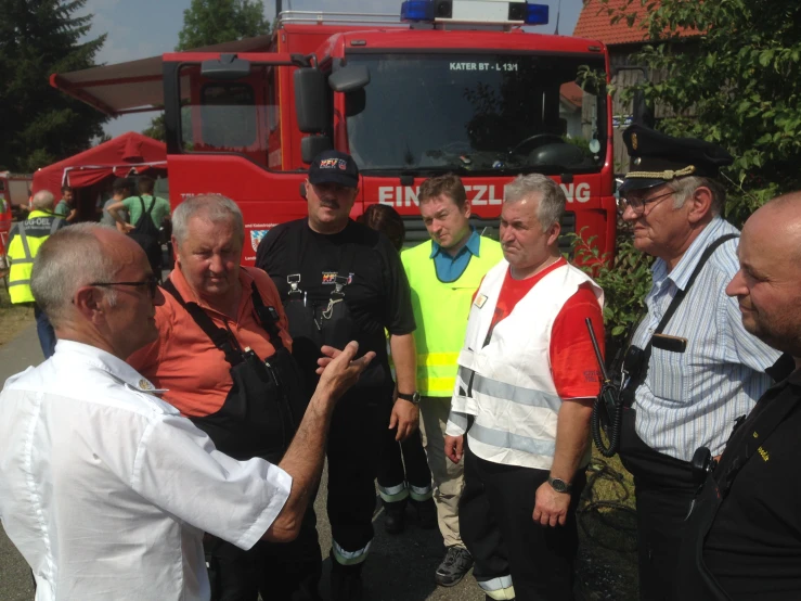 a bunch of people standing around a fire truck