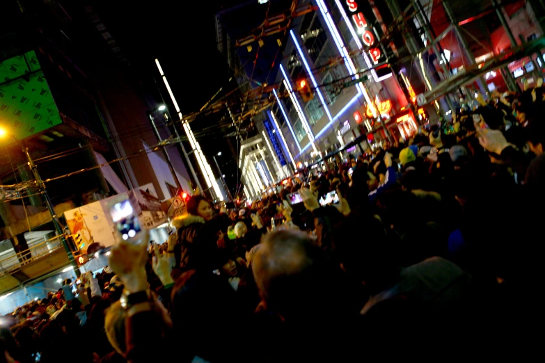 a crowd of people are standing outside at night