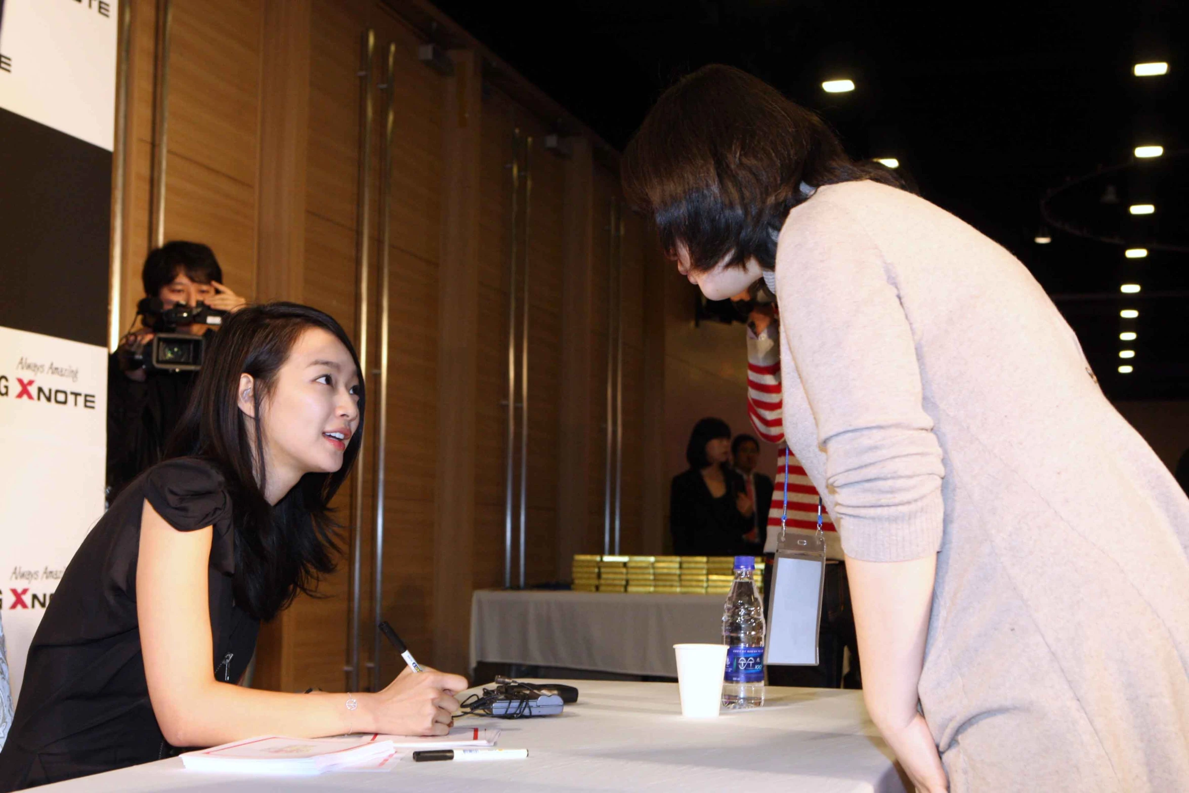 a woman is signing her ticket at an event