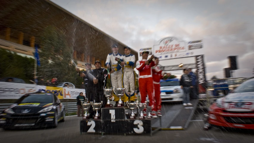 some people standing on top of a race car