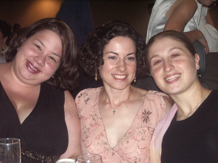 three women at a party posing for a po