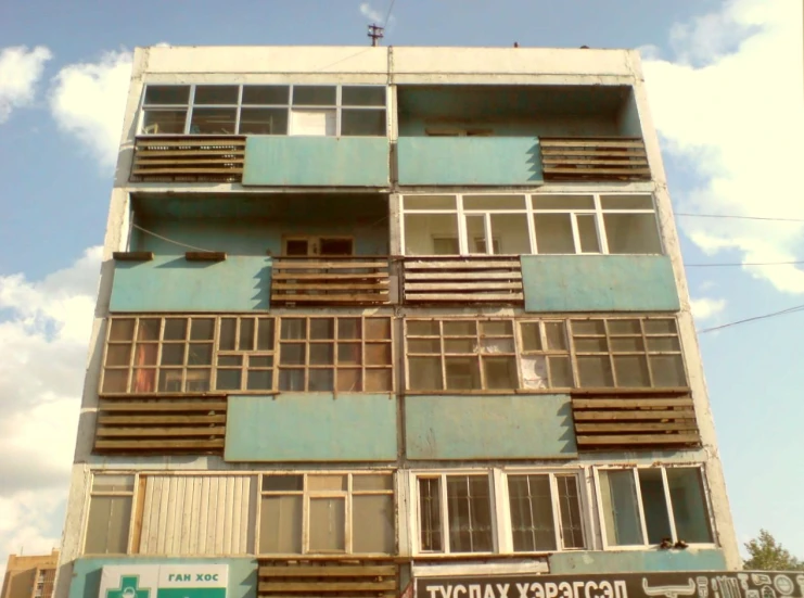 several windows on a very tall building next to a street