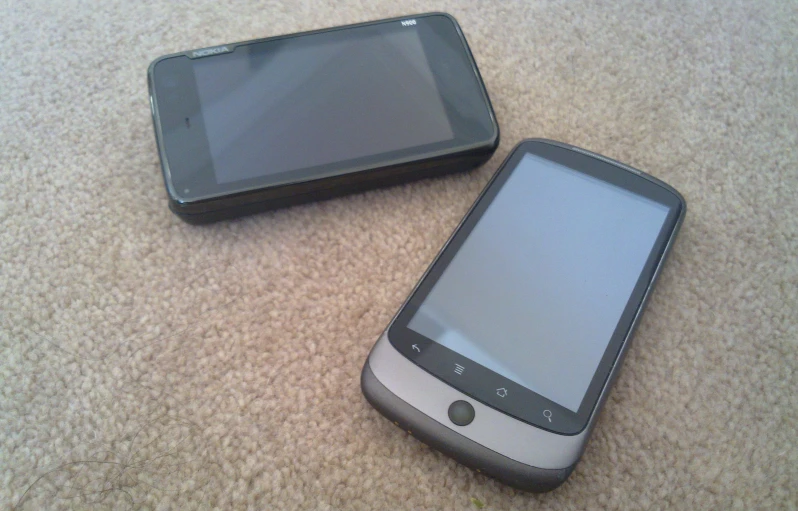 two electronic devices sitting on top of a carpet