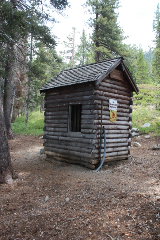 a log cabin in the woods with a no trestle sign