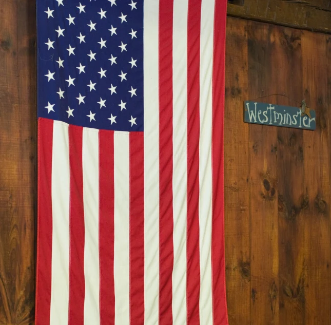 a big flag hanging up next to some brown wood