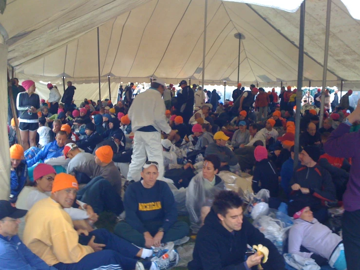 a huge group of people sitting under a tent