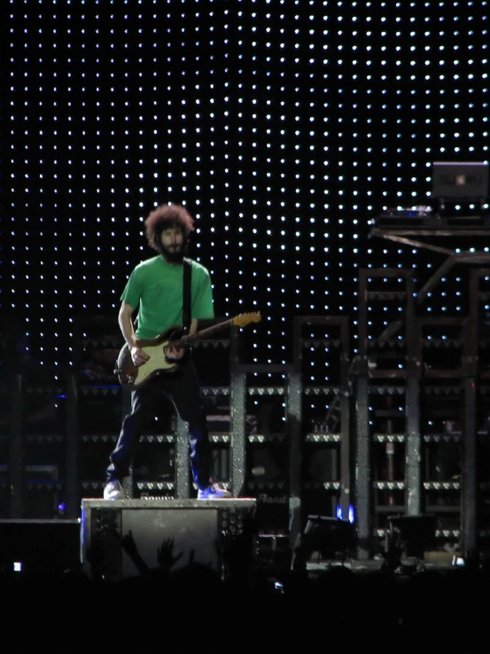 the man is playing his guitar on stage