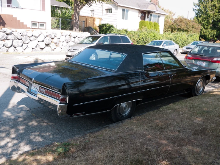 a black car parked in the lot by a house