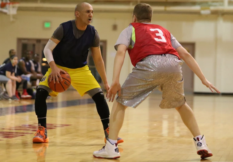 two men are playing basketball inside of a gym