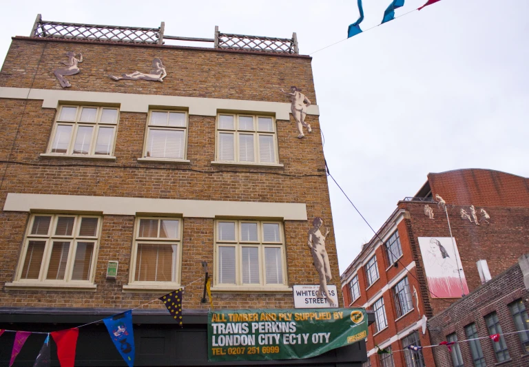 a sign is below buildings with banners around it