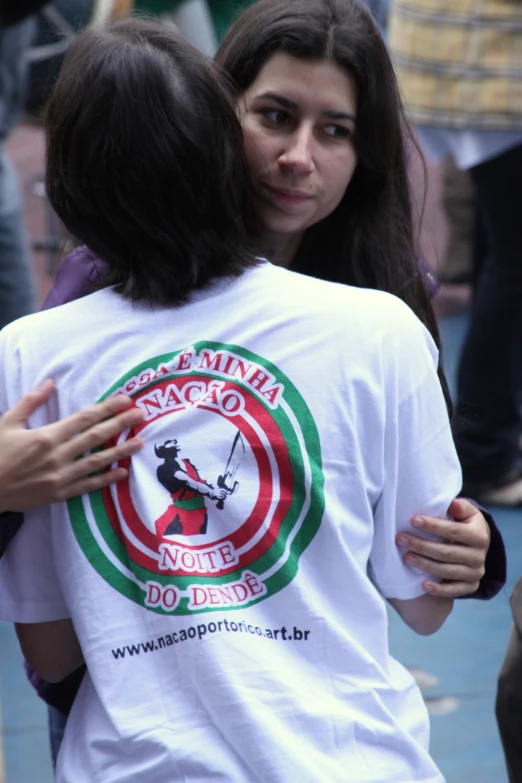 a couple of women hugging each other on the street