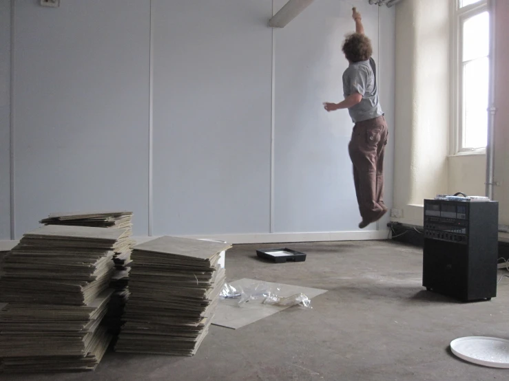 a man standing on a ledge near stacks of records