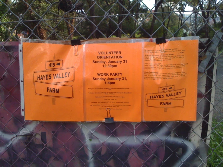 a metal fence covered with orange papers