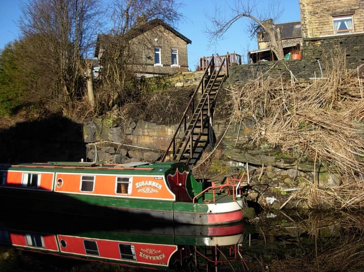 a houseboat with ladder beside a body of water