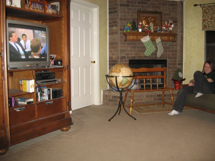 a woman sitting on the floor watching television