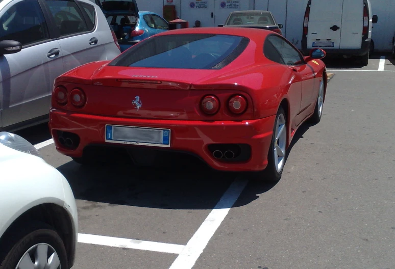 a red sports car is parked in a parking space