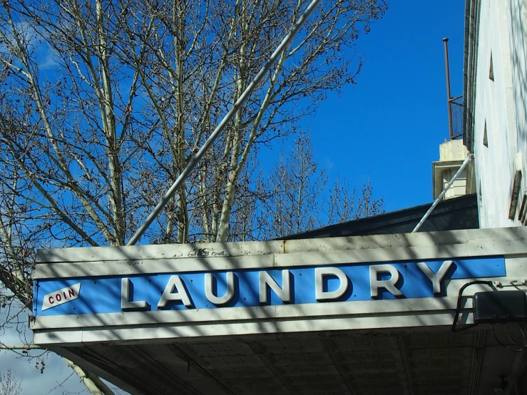 a blue and white sign is near some trees