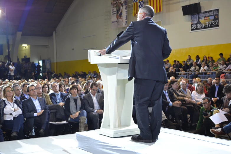 a man in a suit standing behind a microphone