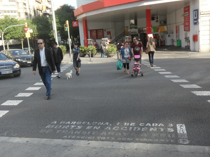 a man and two s crossing a street