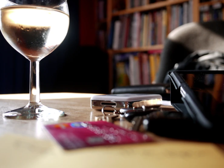 a glass of wine sitting on top of a wooden table