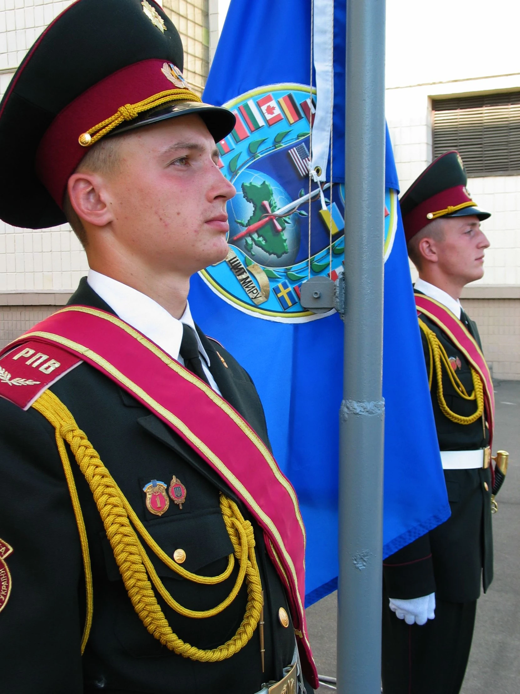 two men in military uniform stand by flags