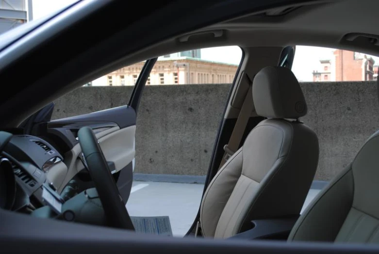 the interior of a car with two white seats