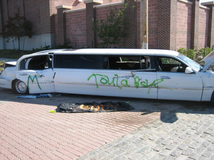a limo with graffiti parked next to a fire hydrant