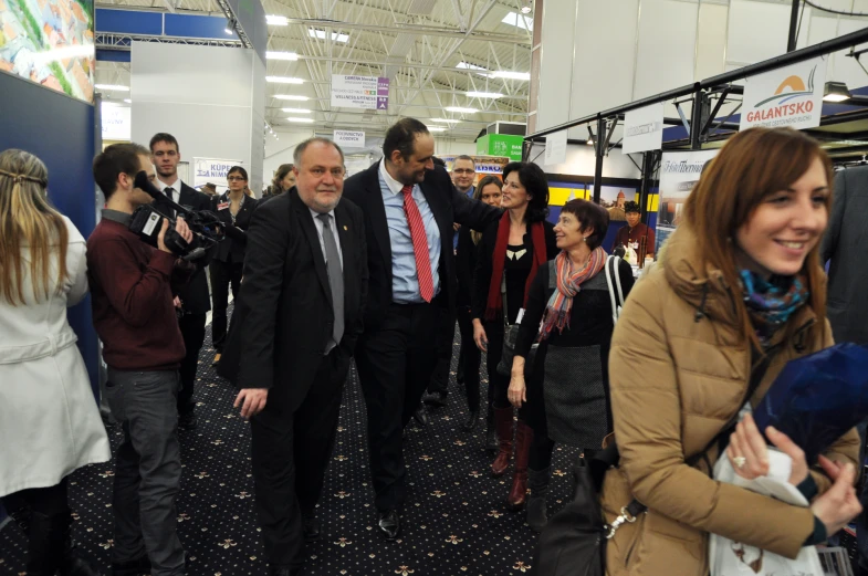 a man in a suit walking with other people