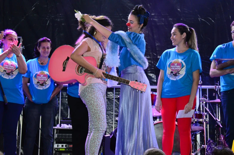 two woman in a dress playing guitar on stage