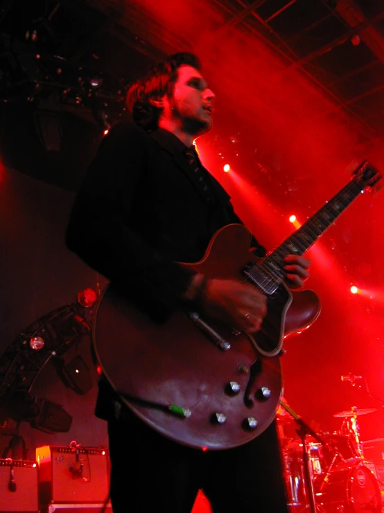 a young man standing at the top of a stage with his guitar